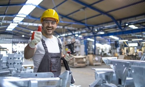 portrait-factory-worker-protective-equipment-holding-thumbs-up-production-hall-min portrait-factory-worker-protective-equipment-holding-thumbs-up-production-hall-min